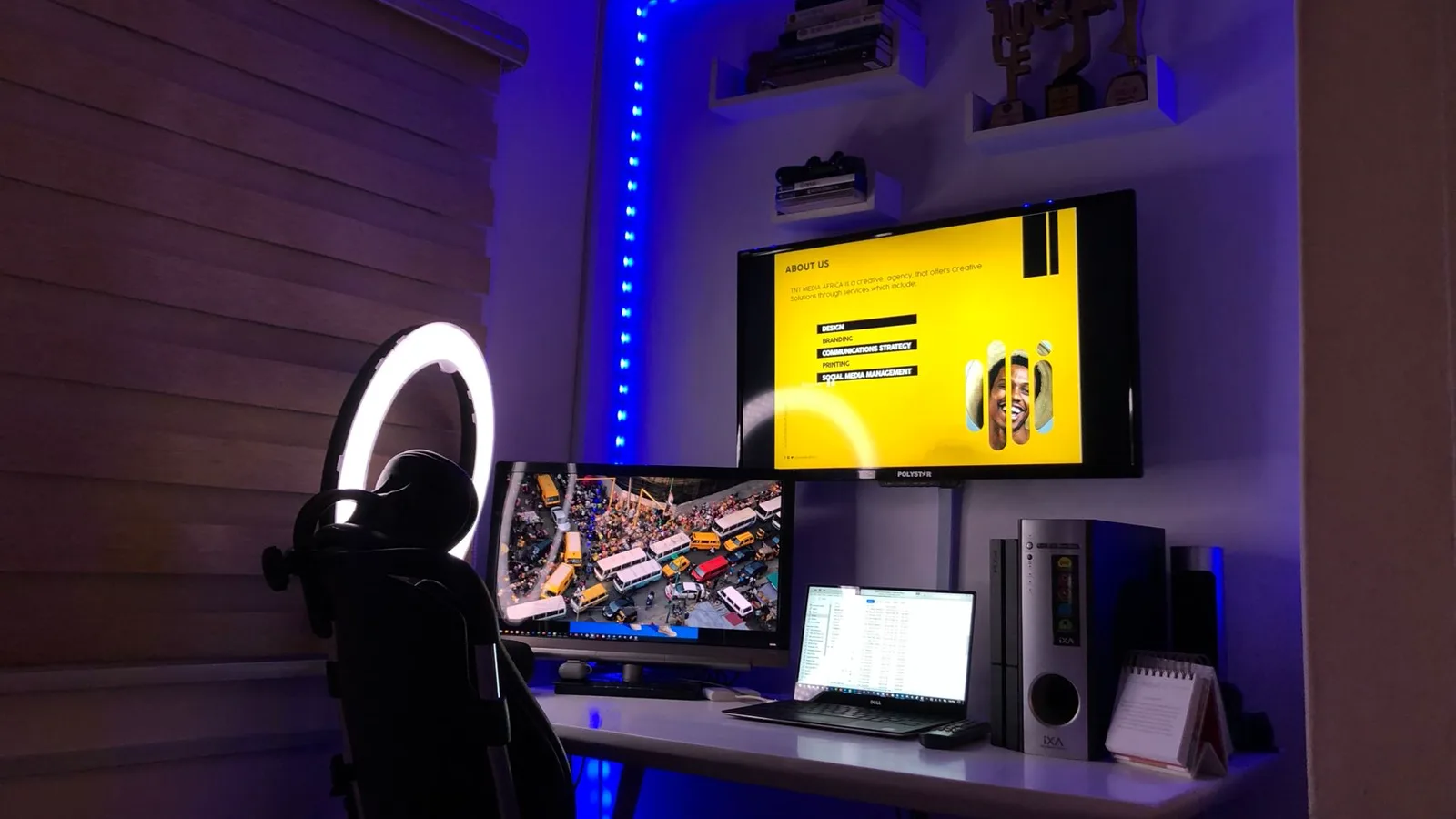 Mão segurando adaptador DisplayPort para HDMI em frente a monitor 4K conectado em um notebook, mostrando os conectores pequenos e a conexão em escrivaninha com iluminação natural